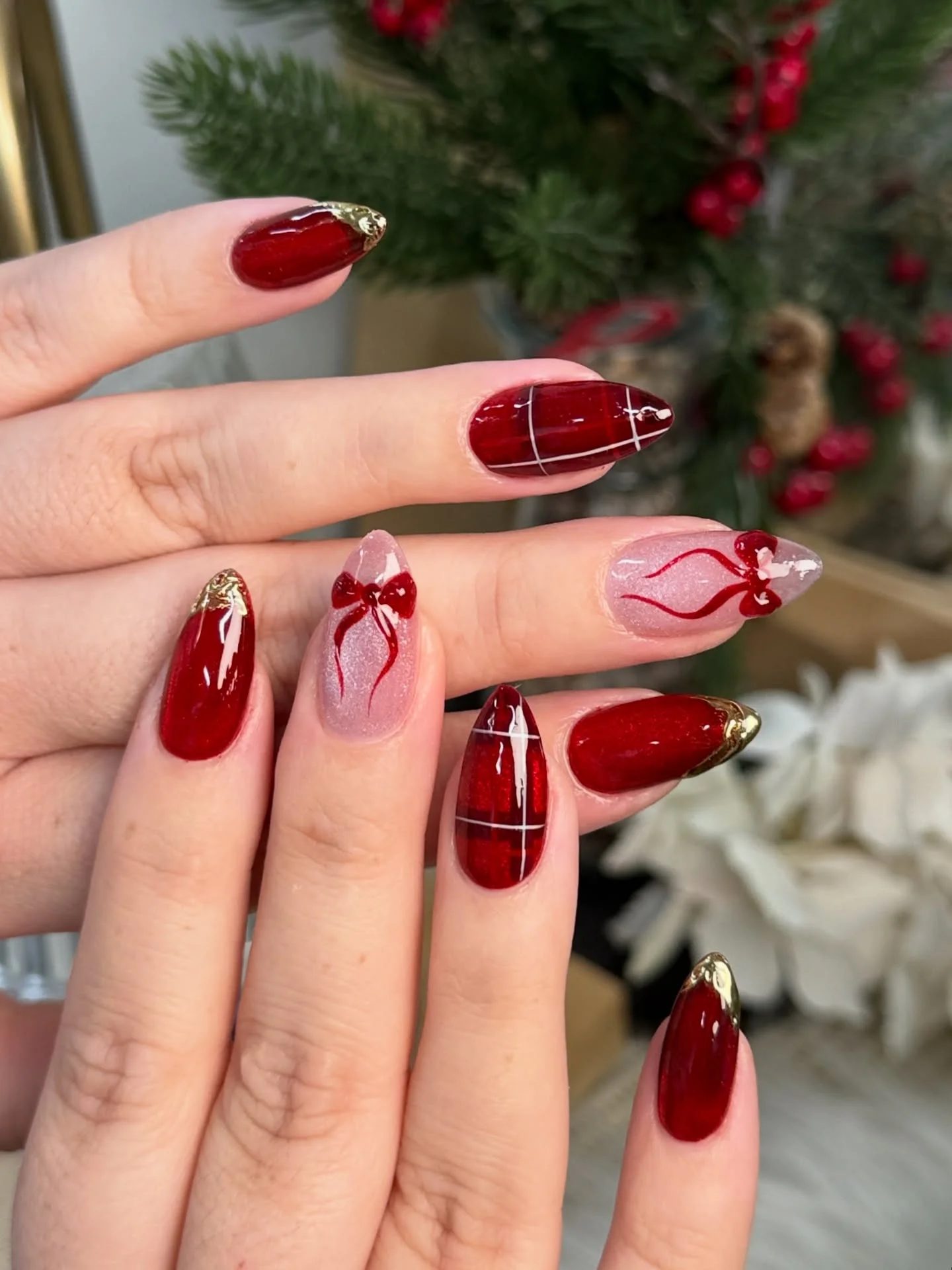 Classic red and gold Christmas nails designs with gold foil tips and bows